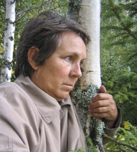 depressed elderly woman leaning on a tree