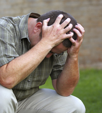 distressed man holding his head in his hands